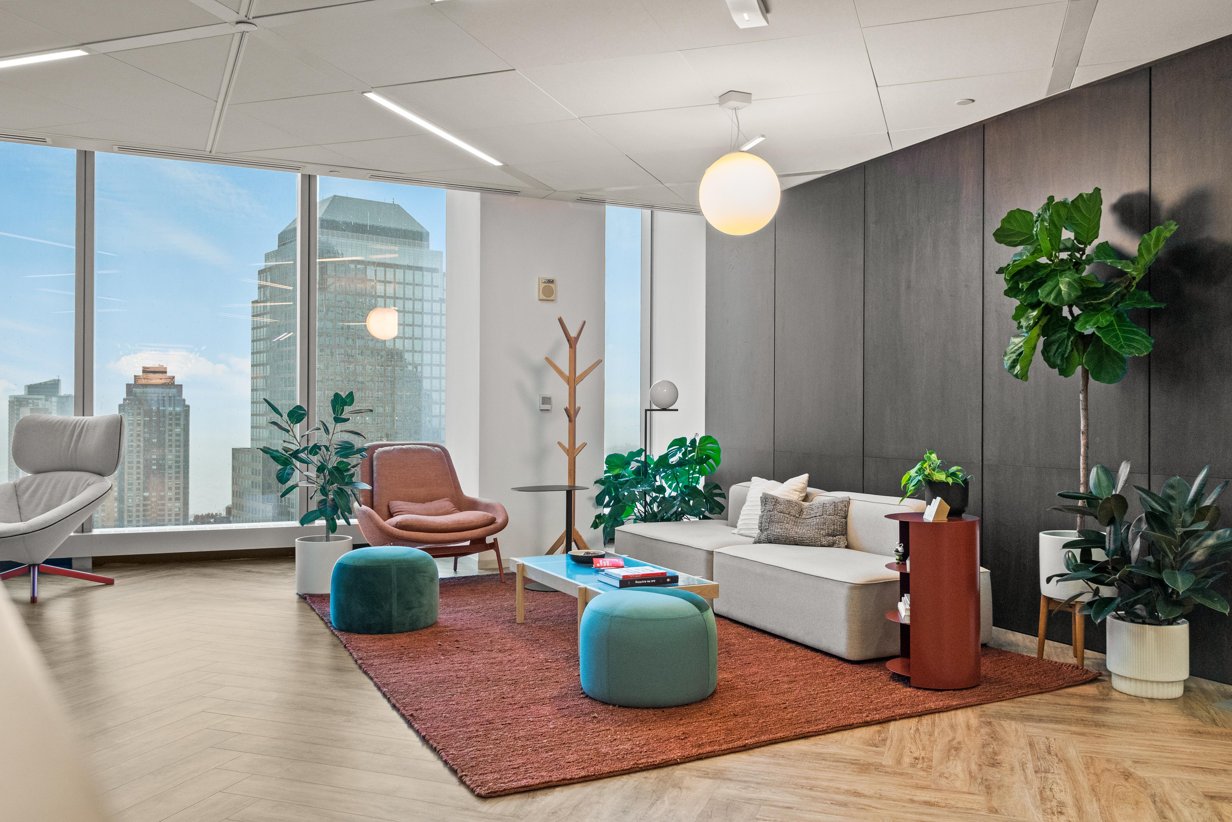 A seating area with plants and large windows in Reddit's New York office.