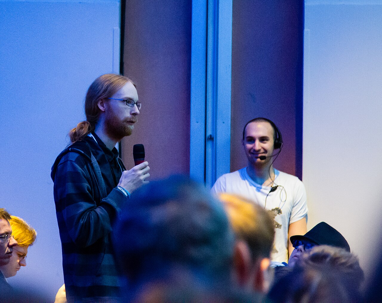 Jens Bergensten holds a microphone at the MineCon 2012 modders panel.
